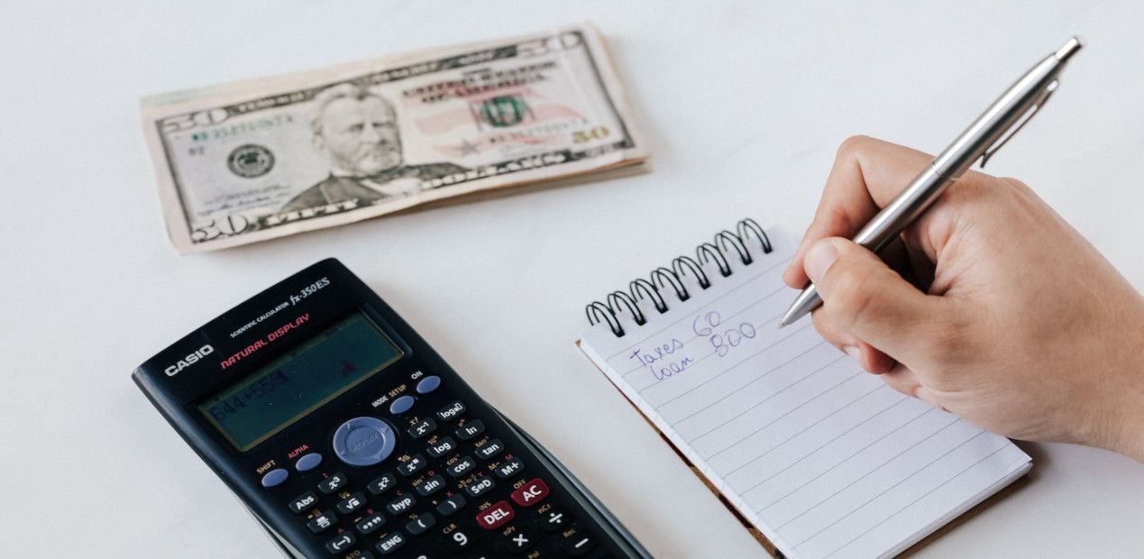 man-bdugeting-on-papaer-with-calculator-on-side